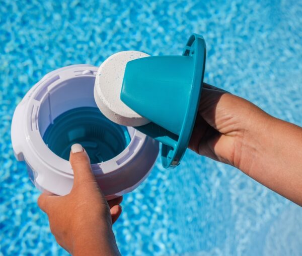 Hands,Placing,Chlorine,Tablet,Into,Pool,Dispenser,For,Water,Treatment