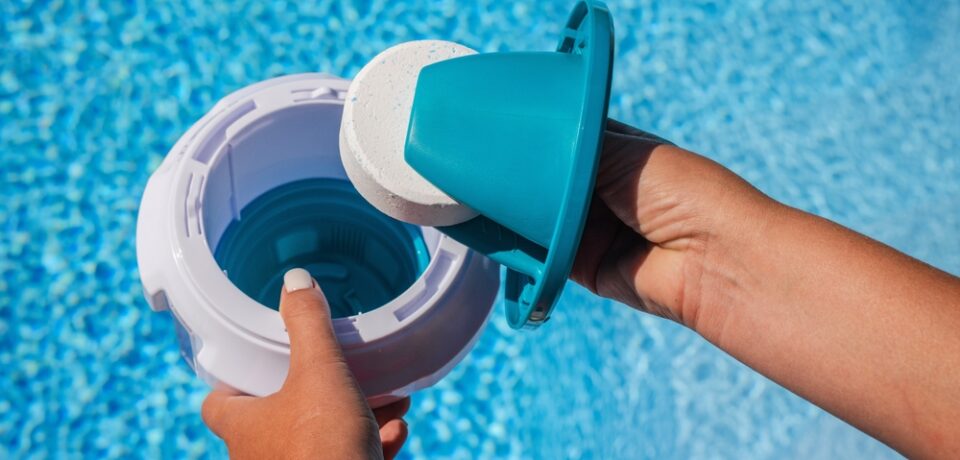 Hands,Placing,Chlorine,Tablet,Into,Pool,Dispenser,For,Water,Treatment