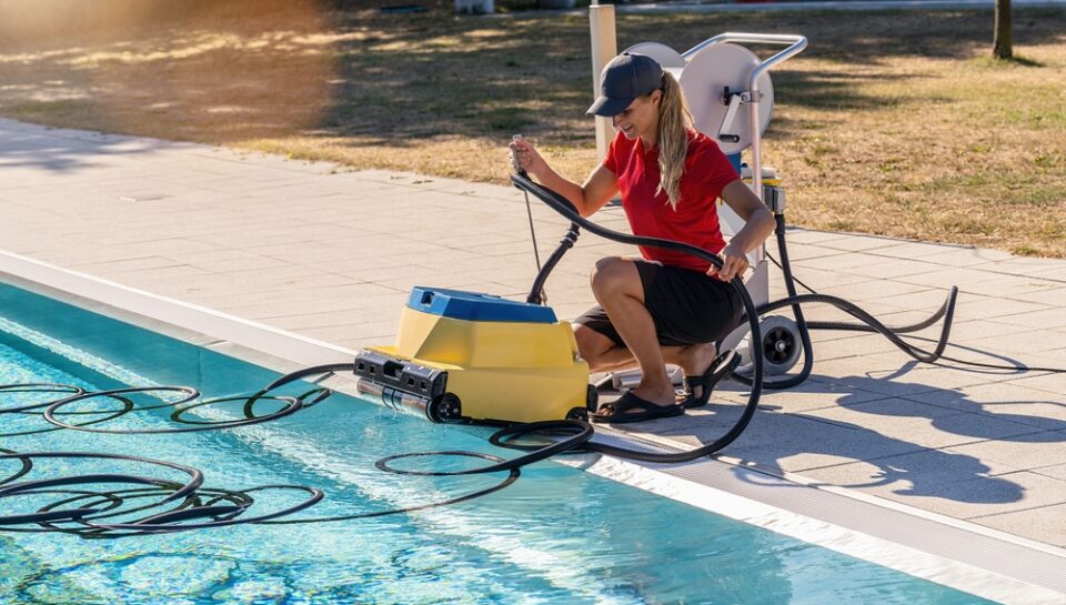 Pool,Technician,Crouching,By,A,Pool,,Handling,A,Robotic,Pool